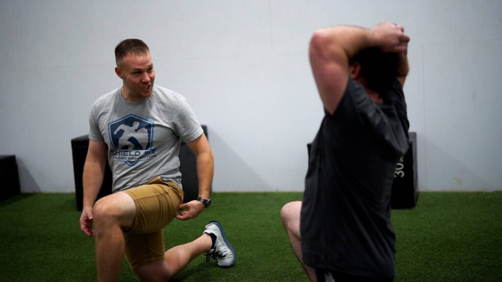 Dr. Nathan Miller of Shield PT demonstrating lunge to PT patient